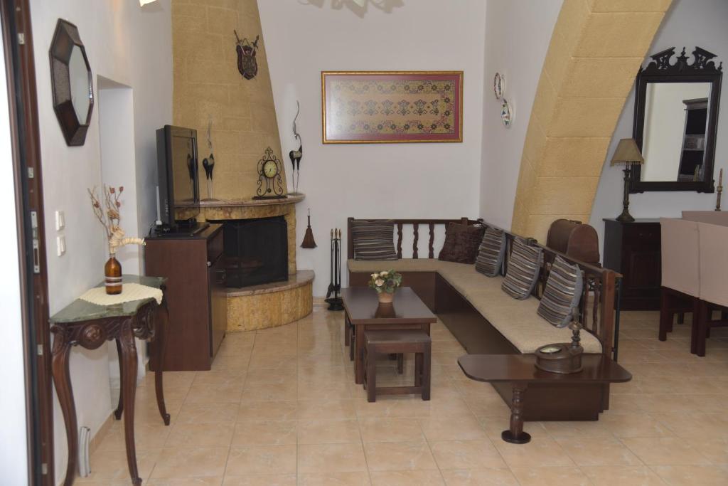uma sala de estar com um sofá e uma lareira em KAMARA traditional house em Soroni