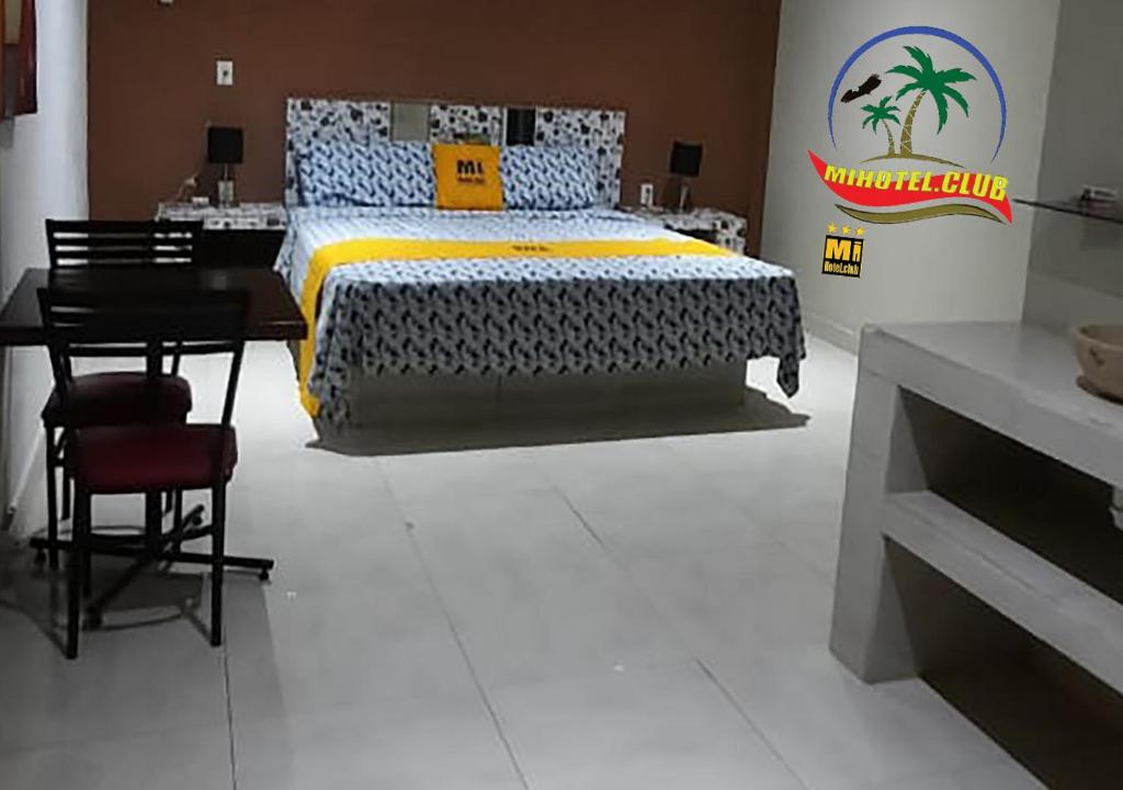 Schlafzimmer mit einem Bett, einem Tisch und einem Schreibtisch in der Unterkunft Mi Hotel Club in Lázaro Cárdenas