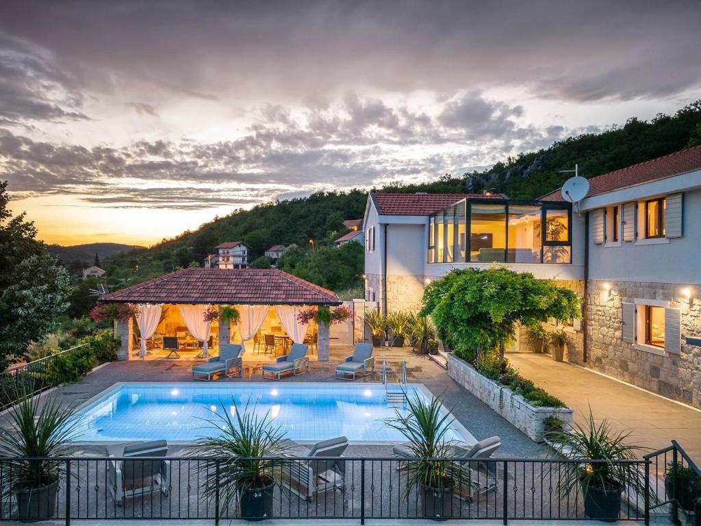 uma villa com uma piscina e uma casa em Krolo Villa&Wine em Trilj
