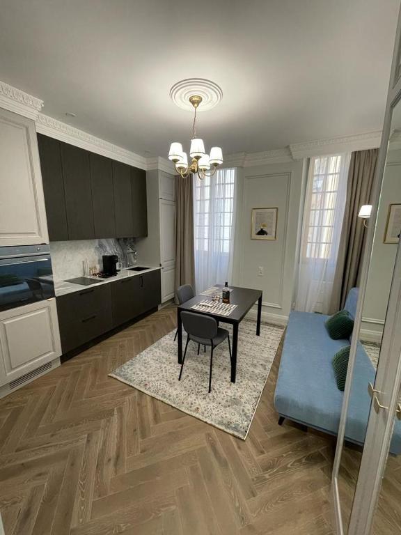 een woonkamer met een tafel en een keuken bij Grand Studio Neuf in Villefranche-sur-Mer