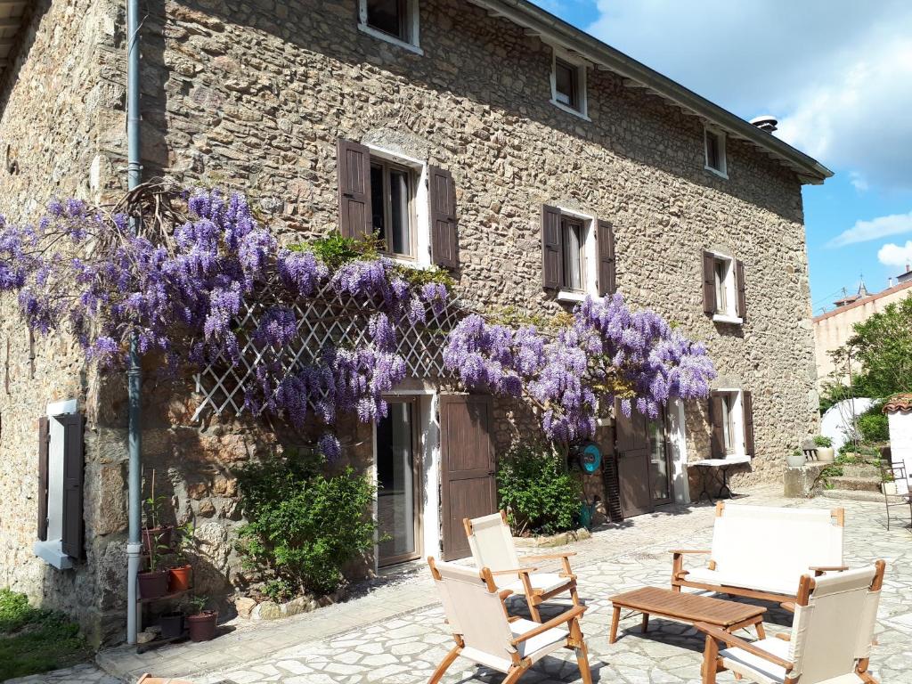 un bâtiment avec des glycérines violettes sur son côté dans l'établissement Un Jardin Secret, à Yzeron