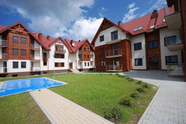 a large house with a yard with a swimming pool at Apartament Lisi Jar in Jastrzębia Góra