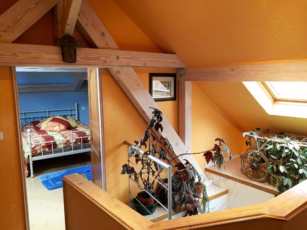 an attic room with a staircase and a bedroom at L'estaminet de la vallée - Le provençal in Russ