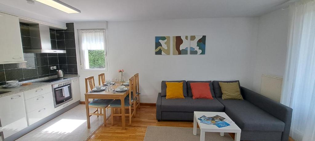 salon z kanapą i stołem w obiekcie Appartement lumineux T3 avec jardin privatif à Hendaye - Parking et wif gratuit w mieście Hendaye