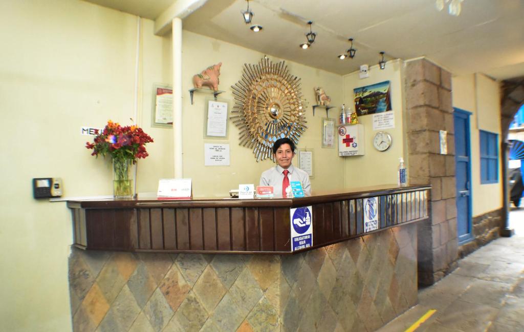 a man is standing behind a counter in a restaurant at Casa Grande Colonial Palace in Cusco