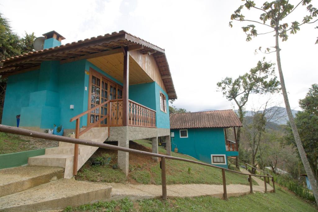 a blue house with stairs in front of it at Chalés Cerejeira in Visconde De Maua