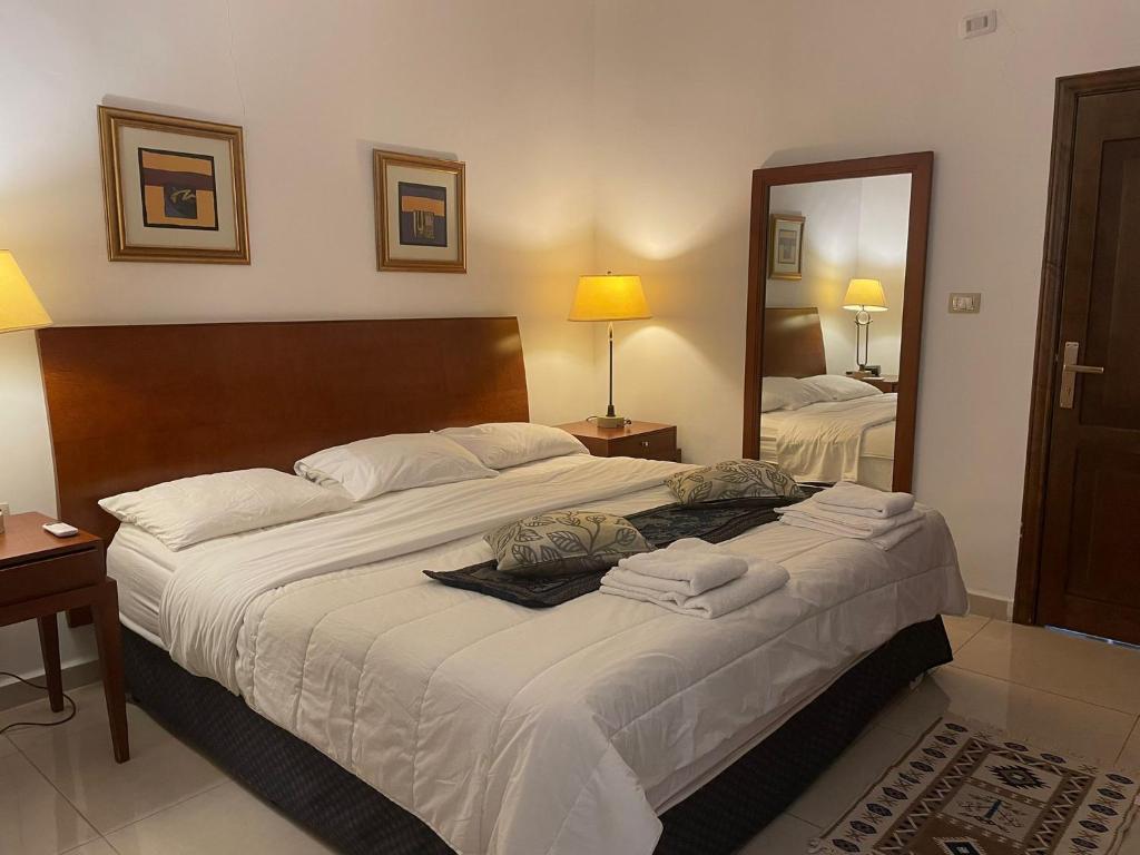 a bedroom with a large bed with towels on it at Tell Madaba Hotel in Madaba