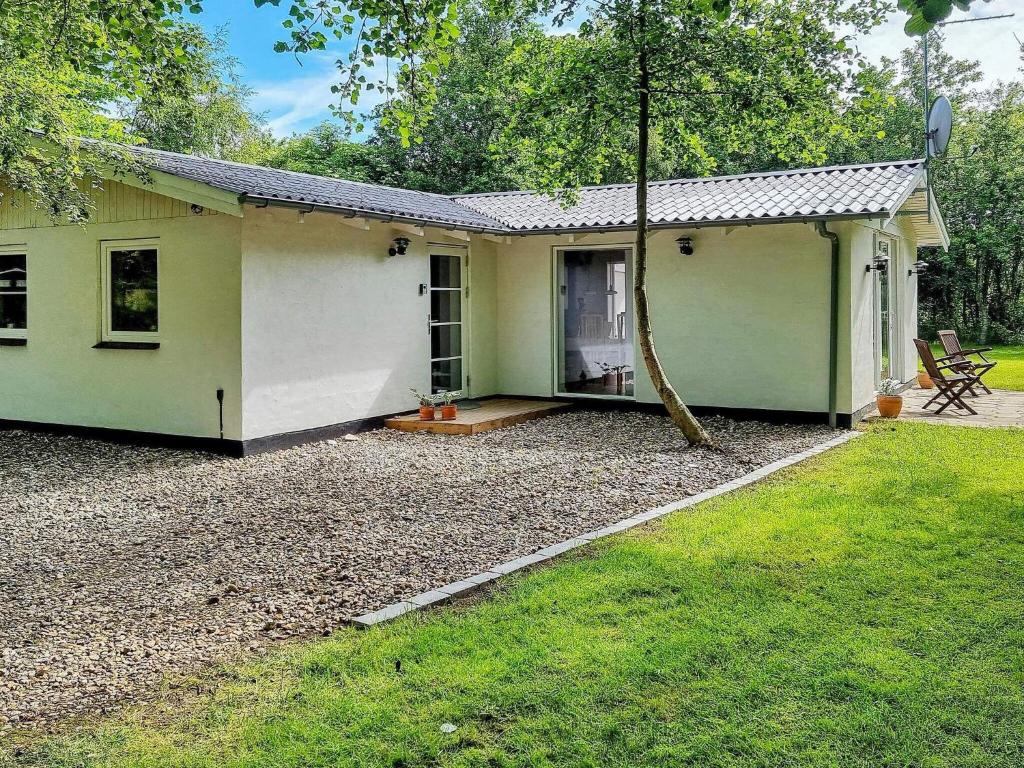 una pequeña casa verde y blanca con patio en Holiday home Hurup Thy XVIII, en Sønder Ydby
