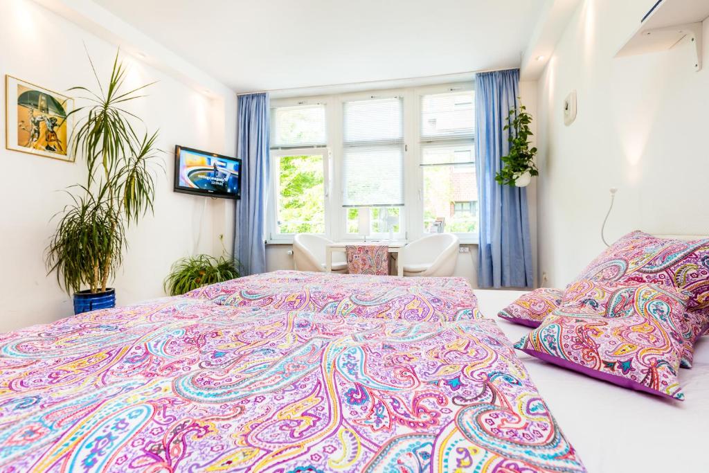 sypialnia z dużym łóżkiem z kolorową narzutą w obiekcie CGN Apartments - Altstadt w Kolonii