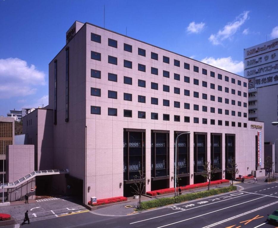a large white building with many windows on a street at Hotel Grand Hill Ichigaya in Tokyo