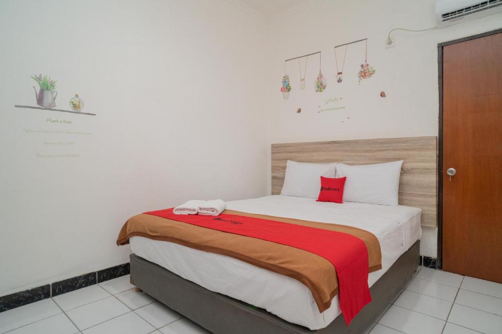 a bedroom with a large bed with red pillows at RedDoorz @ Glodok in Jakarta