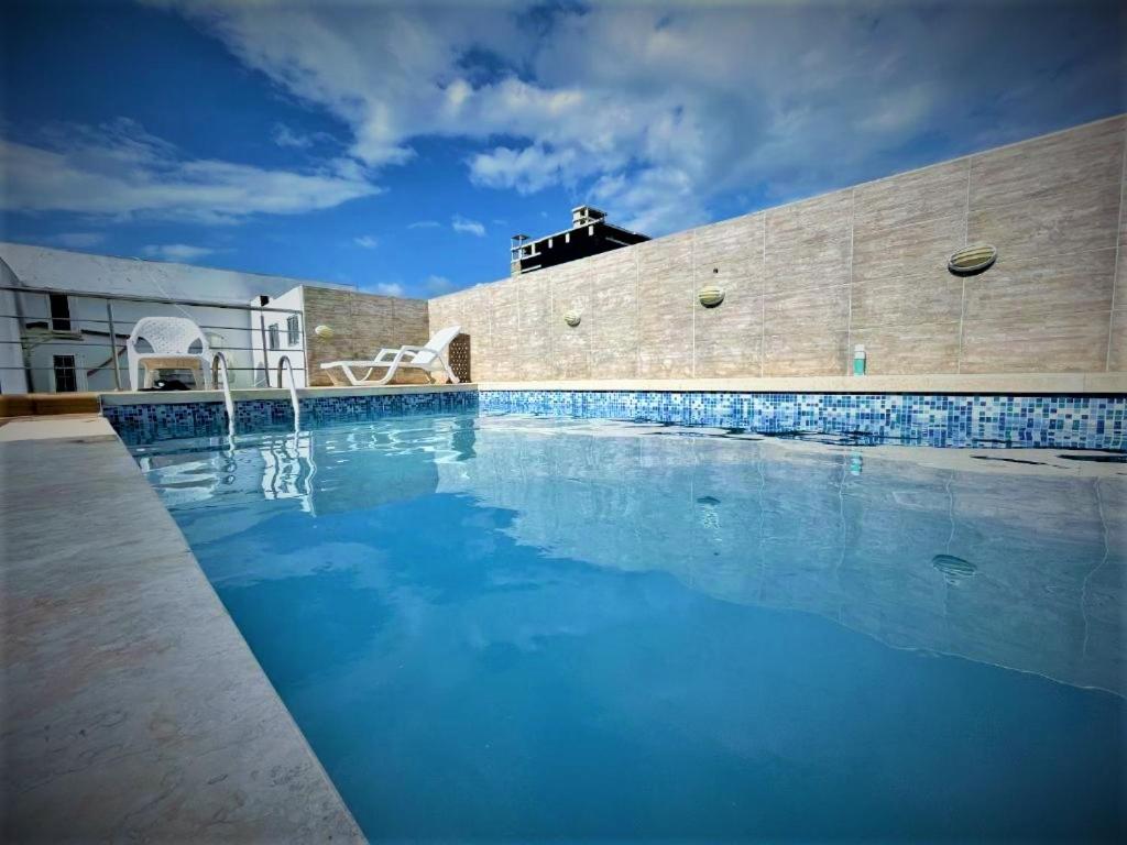 una gran piscina de agua azul frente a un edificio en Hotel Oxford Barranquilla, en Barranquilla