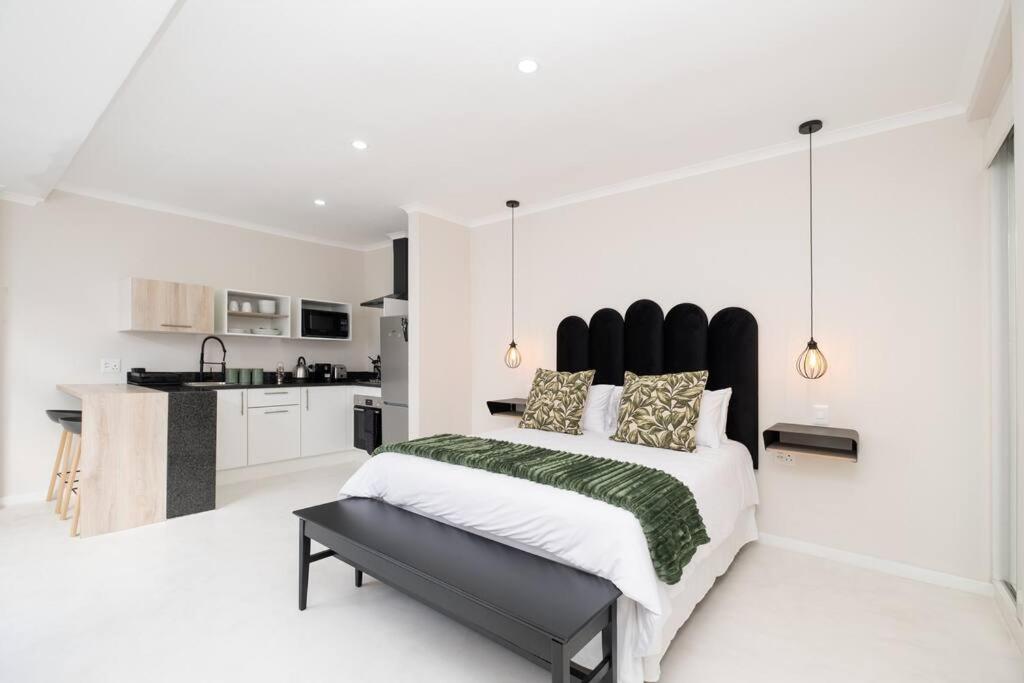 een slaapkamer met een groot bed en een keuken bij 31OnGambia in Johannesburg