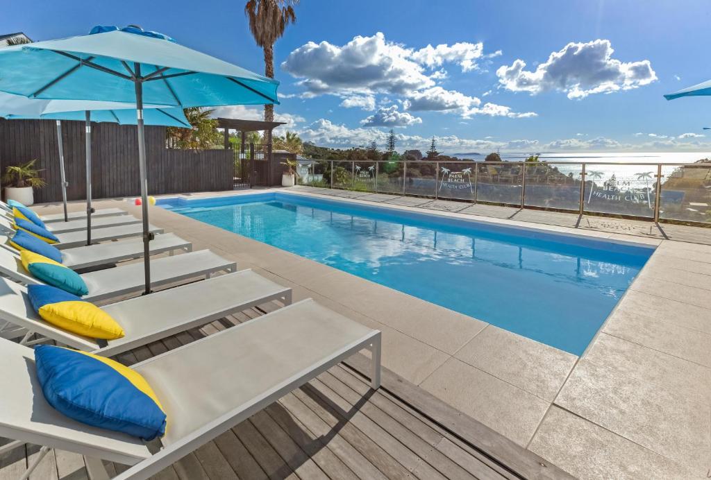 uma piscina com espreguiçadeiras e um guarda-sol em Waiheke Island Resort Conference & Accomodation Centre em Ostend