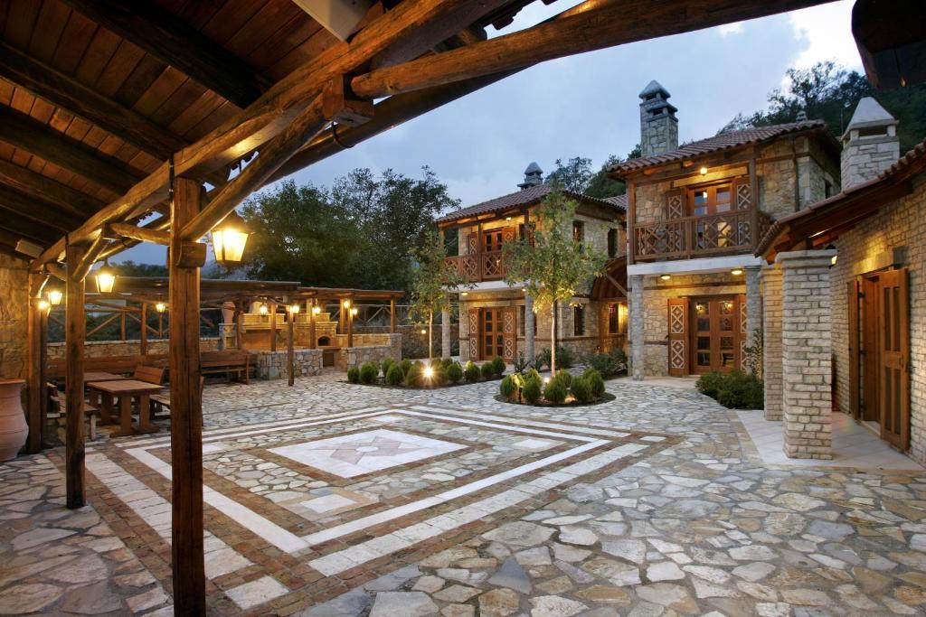 un patio al aire libre con suelo de piedra y una casa en Abeliona Retreat, en Ambeliona
