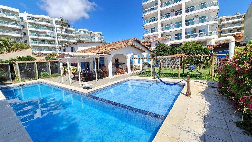 a swimming pool in front of a apartment at POUSADA e HOSTEL ARAUNA in Cabo Frio