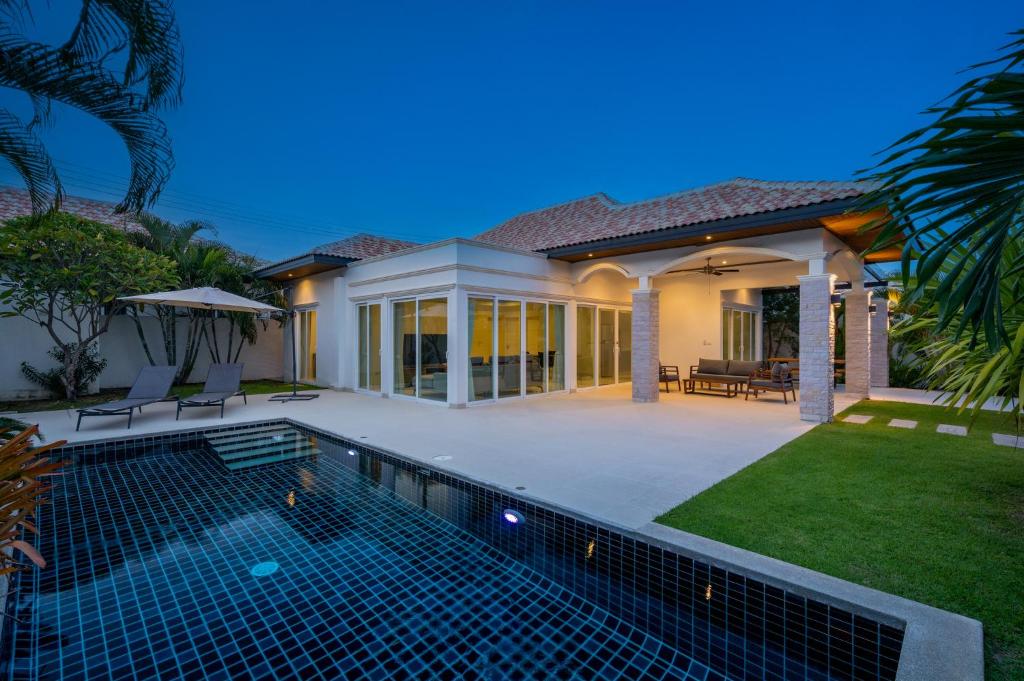 a swimming pool in front of a house at Orchid Paradise Homes OPV429 in Hua Hin