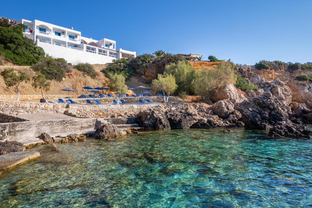 a view of a beach with blue water and a building at Castelia Bay Hotel in Amoopi