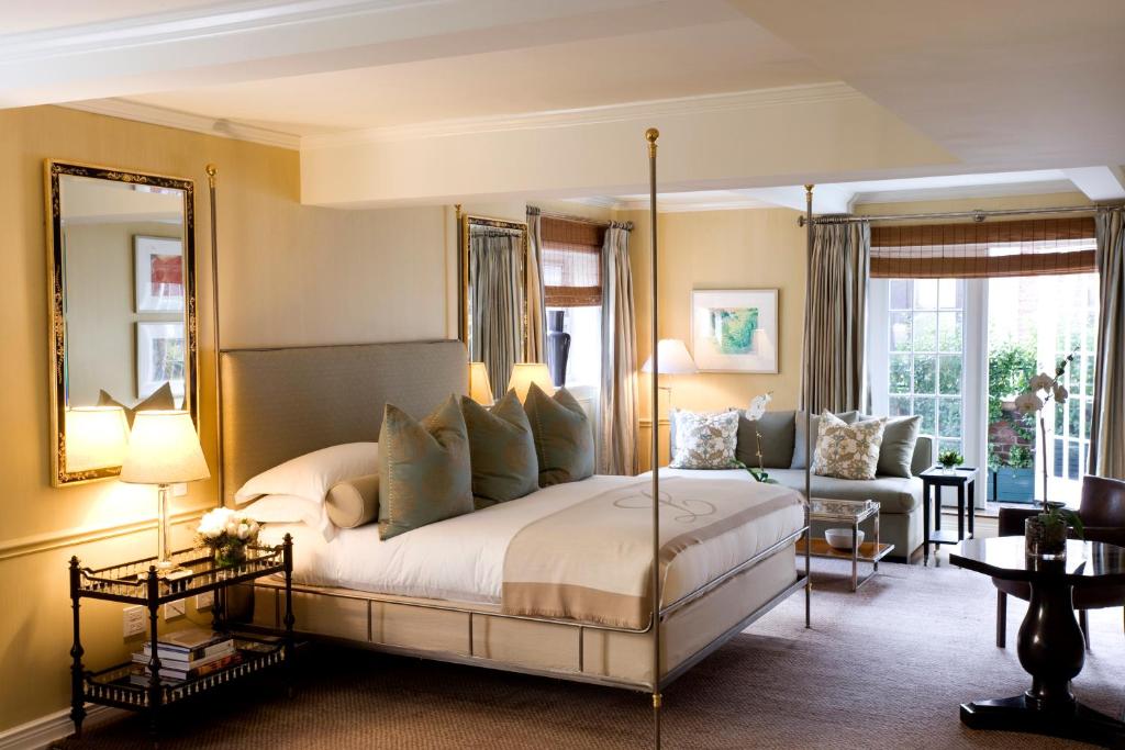 a bedroom with a canopy bed and a living room at Lowell Hotel in New York