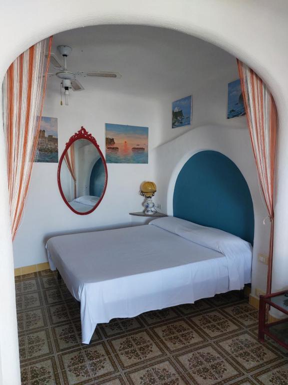 ein Schlafzimmer mit einem großen Bett und einem Spiegel in der Unterkunft Appartamenti Spinesante in Ischia