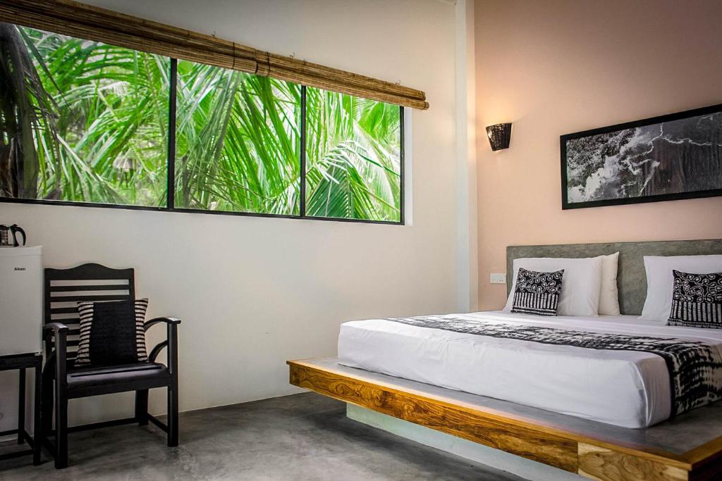 - une chambre avec un lit et une grande fenêtre dans l'établissement Haven Beach Hiriketiya, Serenevilla Properties, à Dikwella