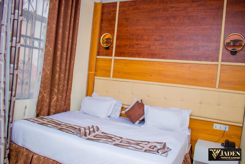 1 dormitorio con 1 cama con sábanas blancas en Jaden Hotel & Lounge - Arusha, en Arusha