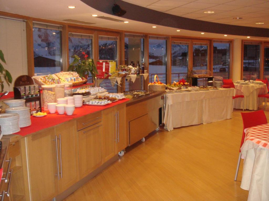 a buffet line in a restaurant with tables and chairs at Hotel Lago Losetta in Sestriere