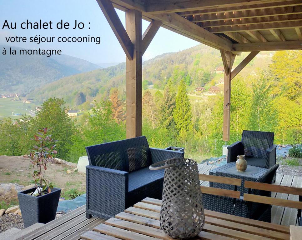 um pátio exterior com 2 cadeiras e uma mesa em Au chalet de JO em Muhlbach-sur-Munster