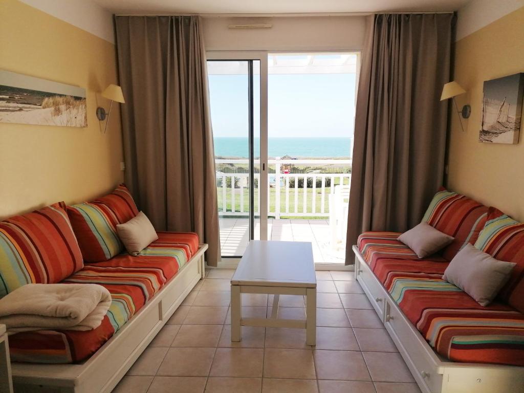 - un salon avec canapés et vue sur l'océan dans l'établissement appartement 4 personnes face mer aux Sables d'Olonne, à Les Sables-dʼOlonne