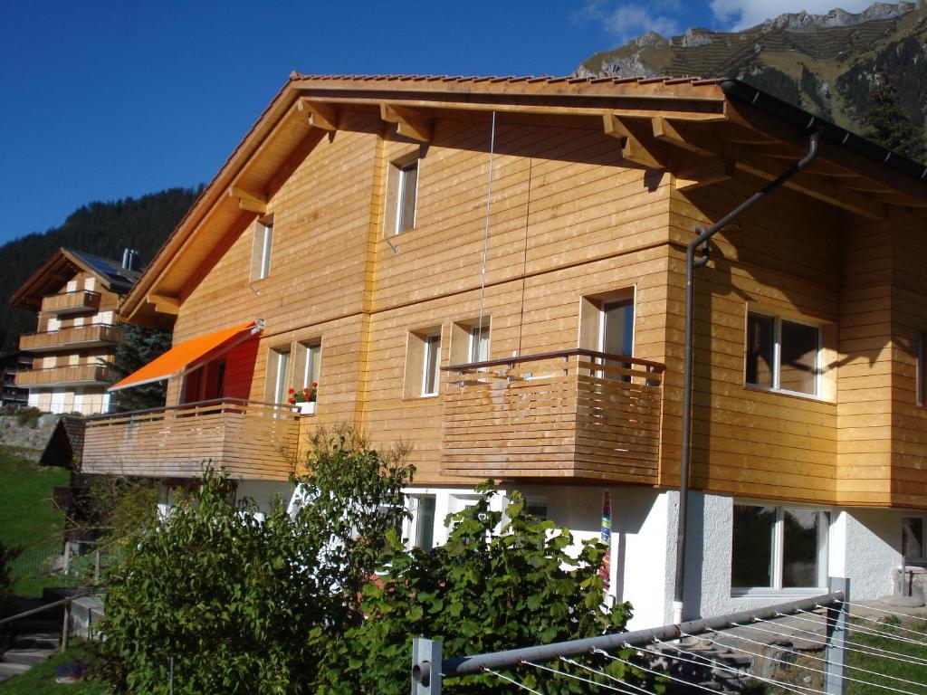 a large wooden house with a large balcony at Chalet Viola in Wengen
