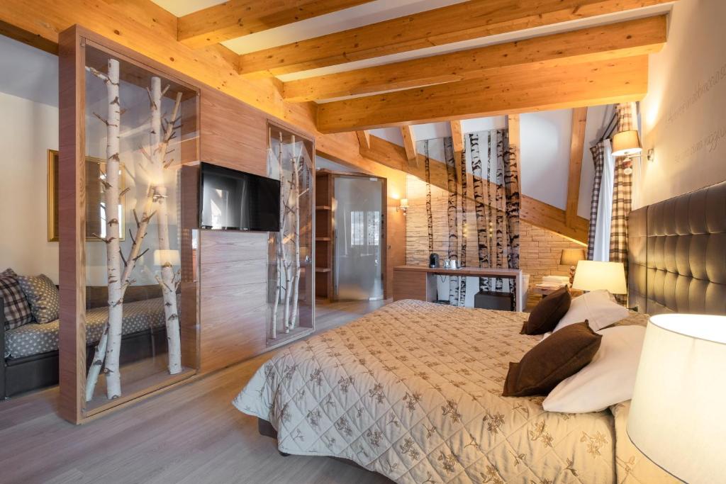 - une chambre avec un grand lit et des murs en bois dans l'établissement Il Piccolo Dolomiti Resort, à Andalo