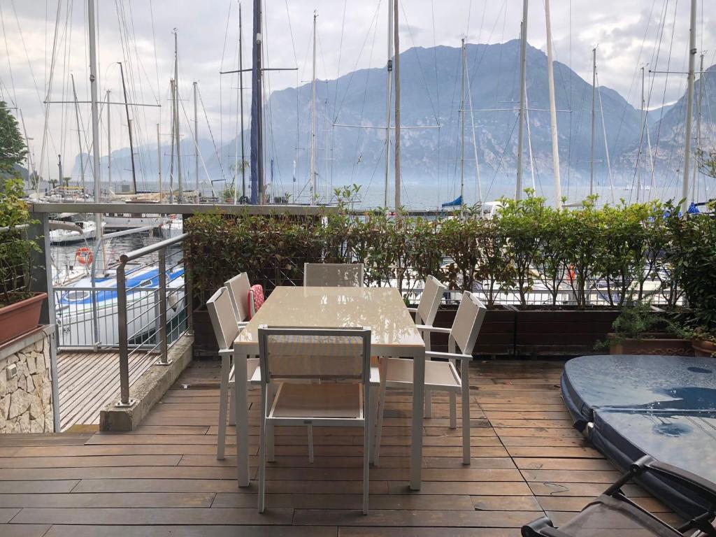a table and chairs on a balcony with a view of a boat at Appartamento Torbole Conca D'Oro in Nago-Torbole