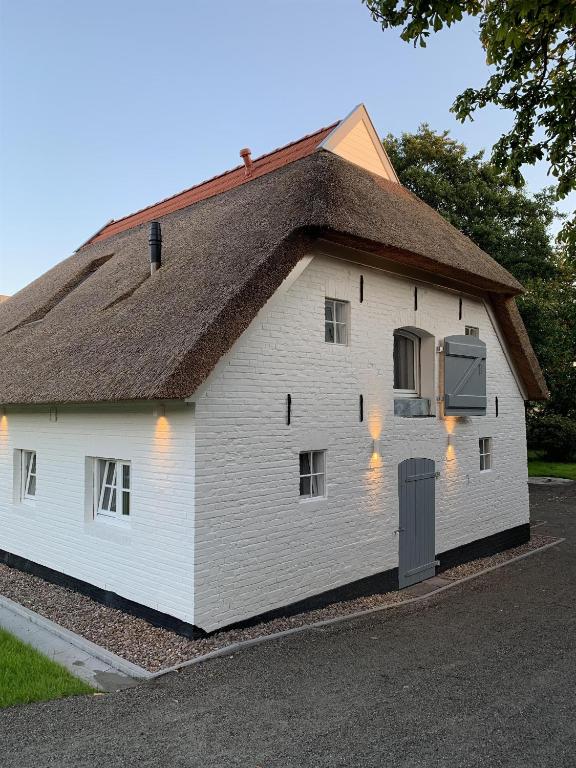 a white building with a roof with lights on it at Hygge-Huus-Burhave in Burhave