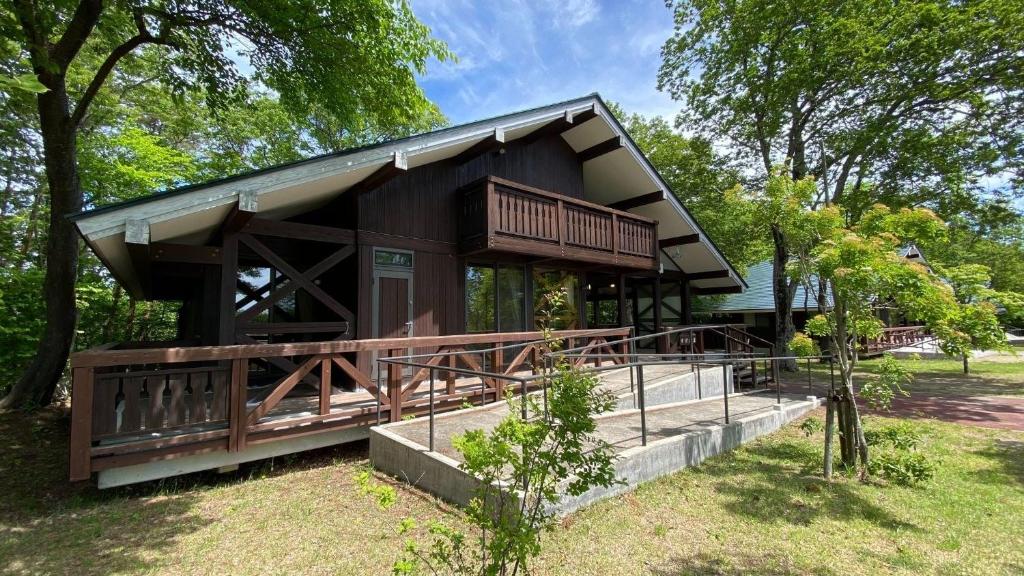 大崎市にあるTabinoteitaku Yakurai Cottageの公園内の大デッキ付き家