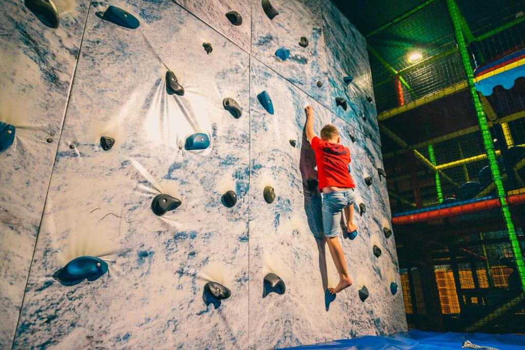 a man is climbing a rock climbing wall at Europarcs Zuiderzee in Biddinghuizen