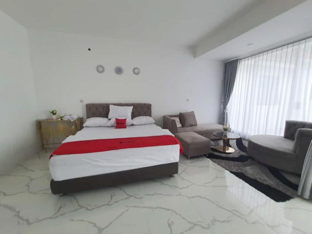 a bedroom with a large bed and a couch at RedDoorz Syariah near Taruna Nusantara Magelang 
