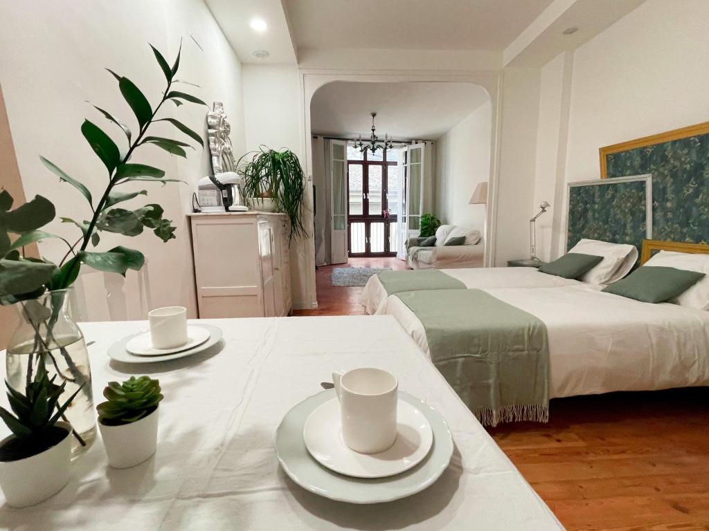 a bedroom with two beds and a table with cups and saucers at Habitación Centro Pamplona - acceso independiente in Pamplona