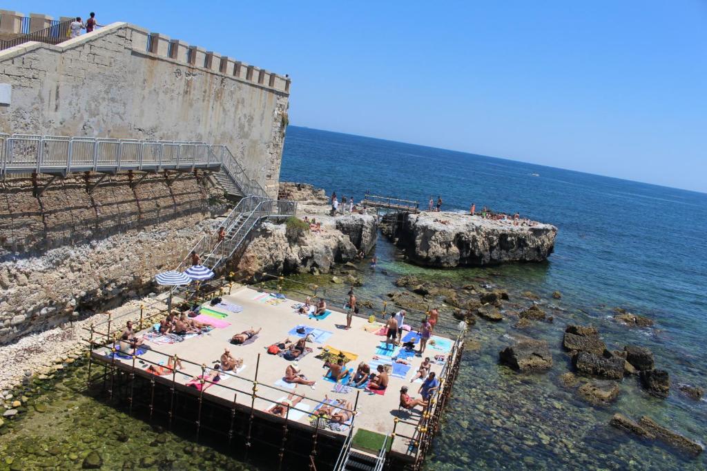 a group of people in the water at a beach at Casa Minniti in Syracuse