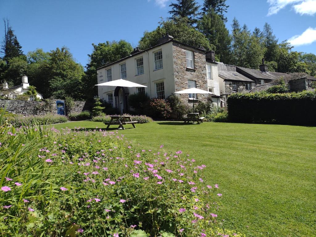 a house with a lawn and flowers in front of it at Rydal Lodge in Rydal