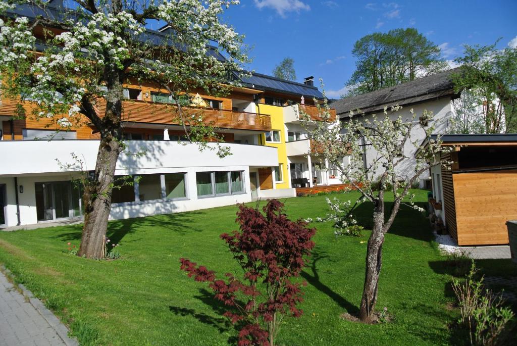 un patio con dos árboles frente a un edificio en Appartement Christine, en Eben im Pongau