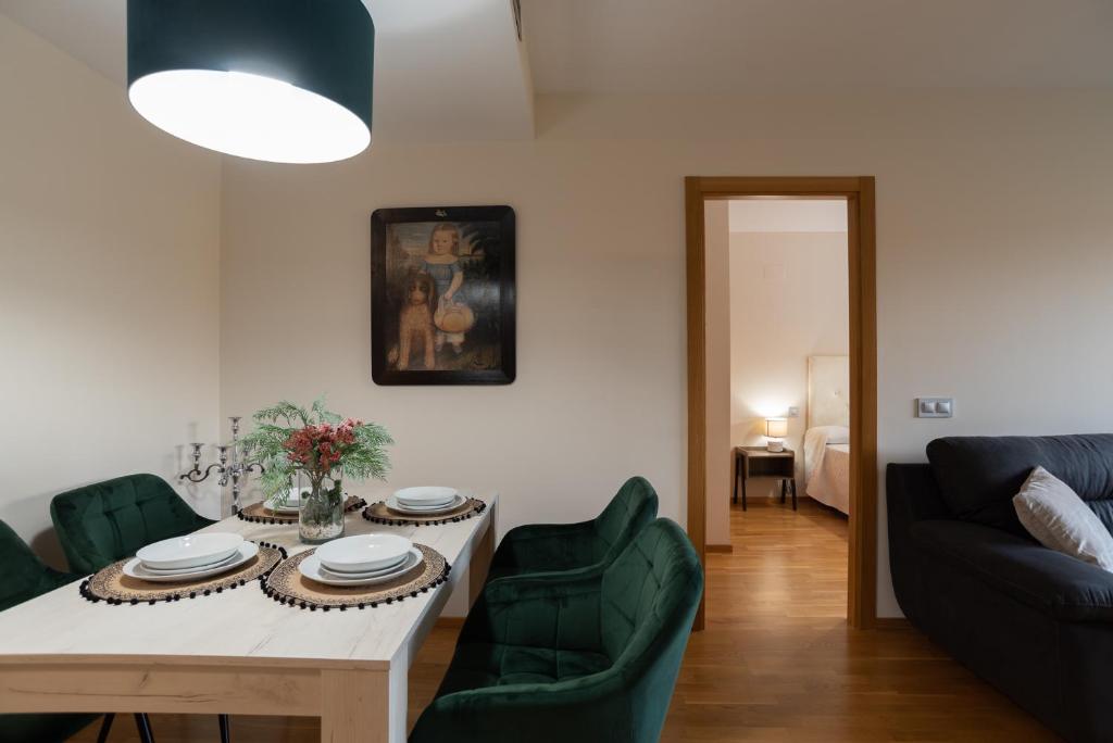 ein Wohnzimmer mit einem Tisch und grünen Stühlen in der Unterkunft Apartamento Bulevar 1 con parking gratuito in Castellón de la Plana
