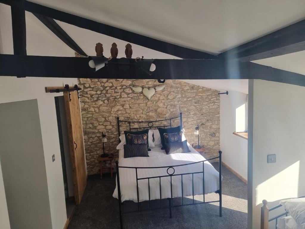 um quarto com uma cama e uma parede de pedra em Monkton Court House B&B em Honiton