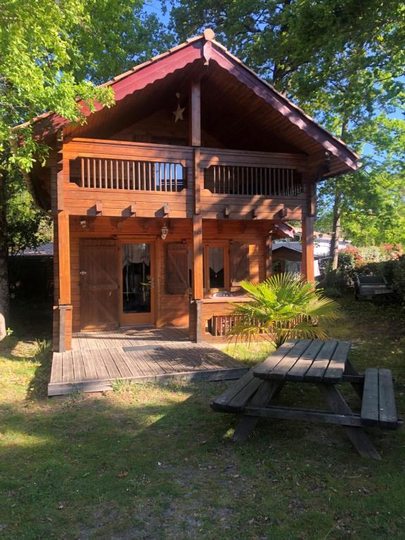 a log cabin with a picnic table in front of it at chalet 143 bassin d'Arcachon in La Teste-de-Buch