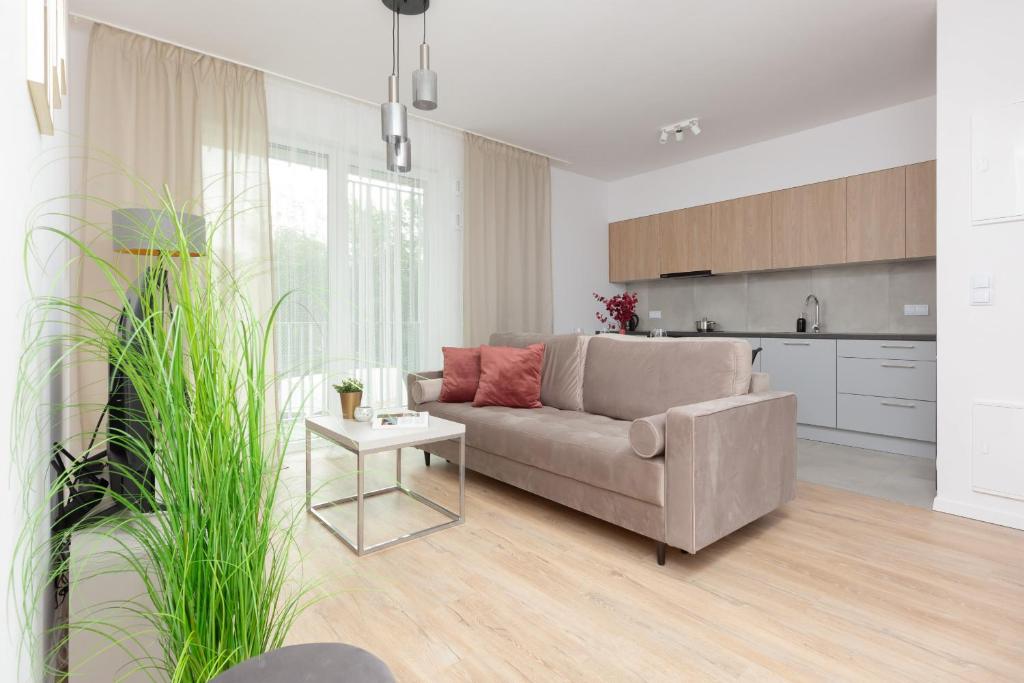 a living room with a couch and a table at Stacja Wola Apartment Gumińska by Renters in Warsaw