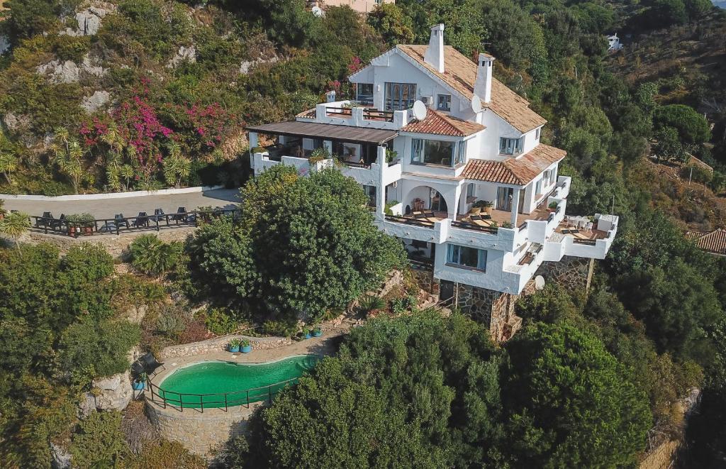 uma casa grande numa colina com um campo de golfe em B&B Muse Marbella em Marbella