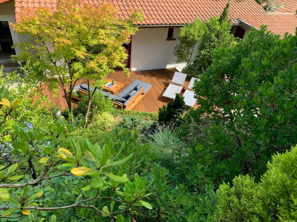 - une vue aérienne sur un jardin avec des chaises et des arbres dans l'établissement Villa élégante, jardin bucolique, proche golf & plages, 4 étoiles - FR-1-239-698, à Capbreton