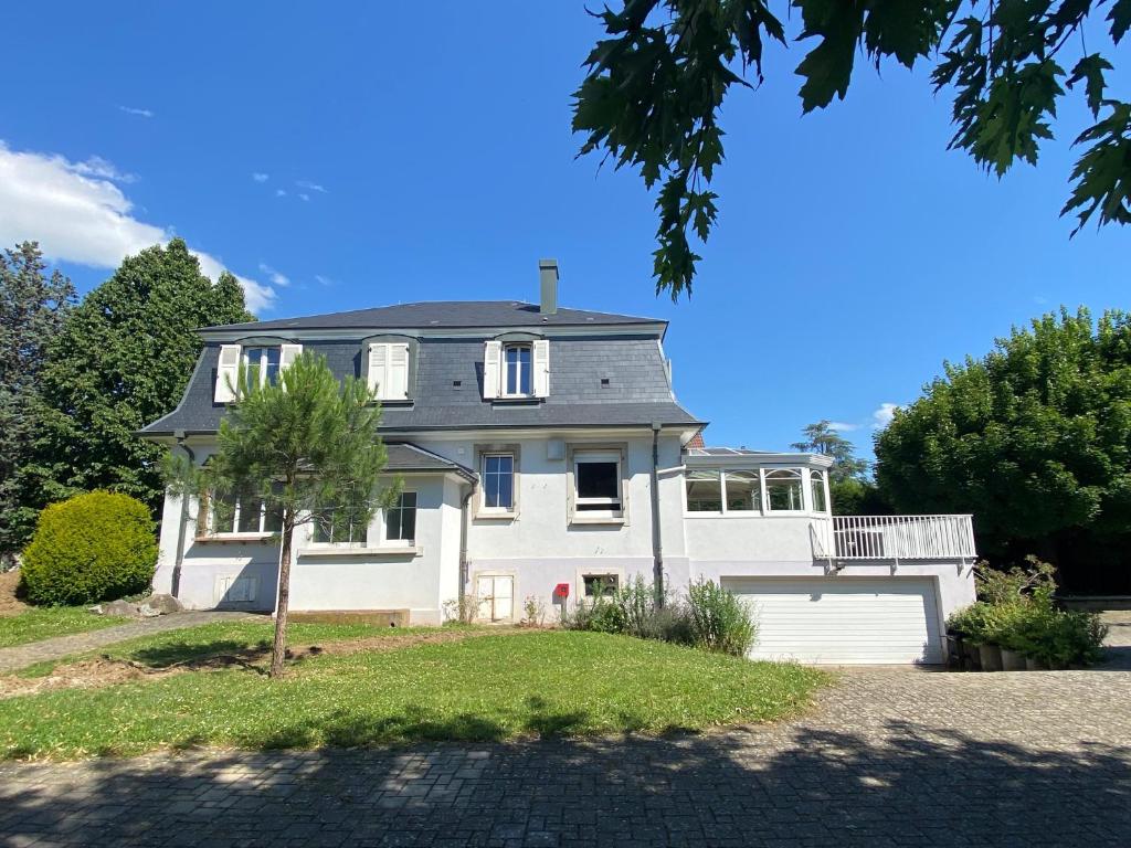 una gran casa blanca con garaje en Magnifique villa à 5 minutes de Colmar, en Horbourg