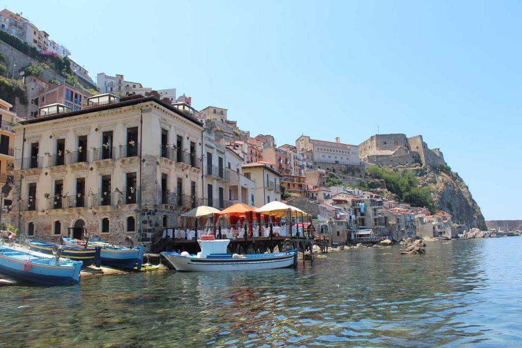 un gruppo di imbarcazioni nell’acqua accanto agli edifici di Principe Di Scilla a Scilla