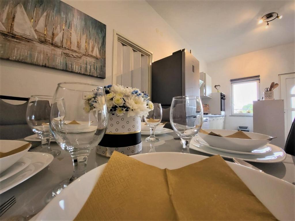 una mesa de comedor con copas de vino y un arreglo floral en Apartment LANA en Svetvinčenat