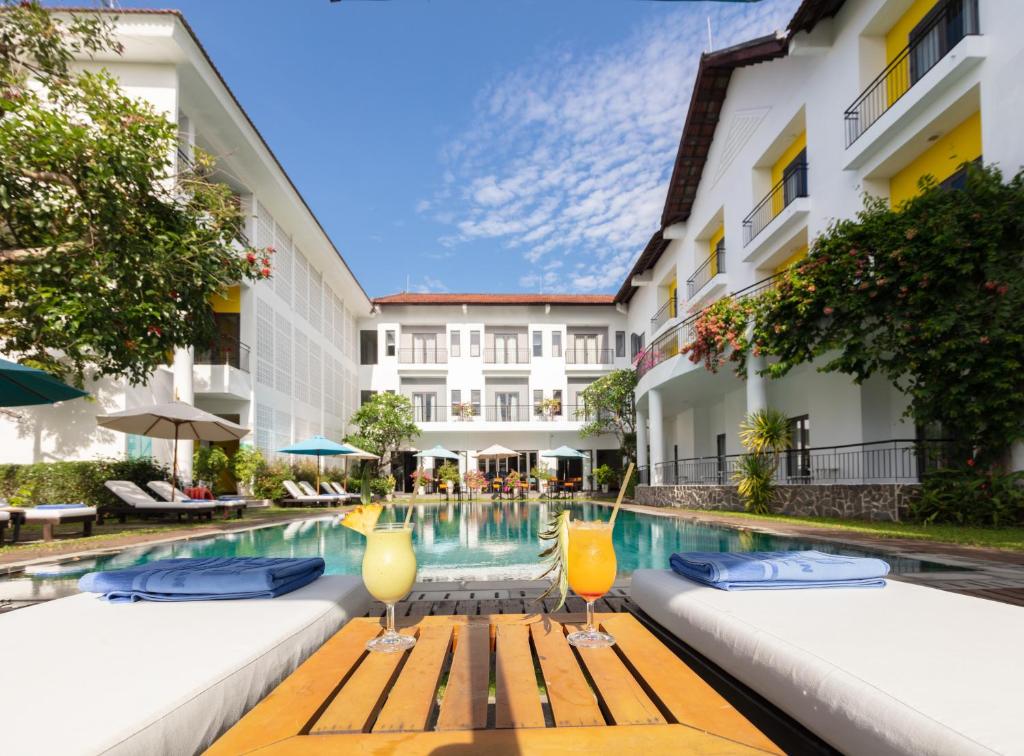 an image of a hotel swimming pool with two cocktails at ÊMM Hotel Hoi An in Hoi An